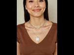 Close-up video of Ellie’s Button Necklace showing gold charm detail and delicate chain movement in natural light