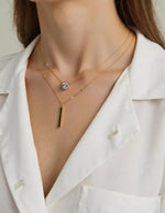 Necklace featuring gold bar pendant and crystal accent