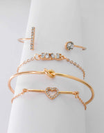 Gold couple bracelets featuring sparkling heart centre charm