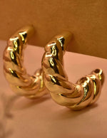 Chunky gold dangle earrings with twisted design
