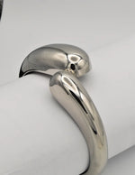 side view of silver bangle bracelet showing reflective smooth surface