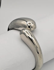 side view of silver bangle bracelet showing reflective smooth surface