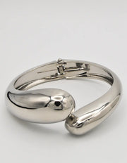 silver bangle bracelet paired with clean girl rings on wrist