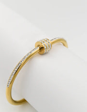 Close-up of gold arm cuff bracelet with sparkling zircons