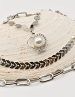 close up of christmas necklace with pearl heart pendant on silver layered chains – trending clean girl jewelry 2025 in canada