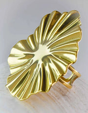 Gold leaf-shaped brooch on a light background